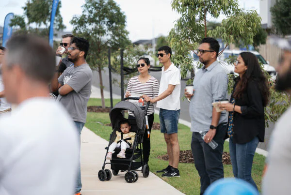 People standing on a footpath casually watching an event